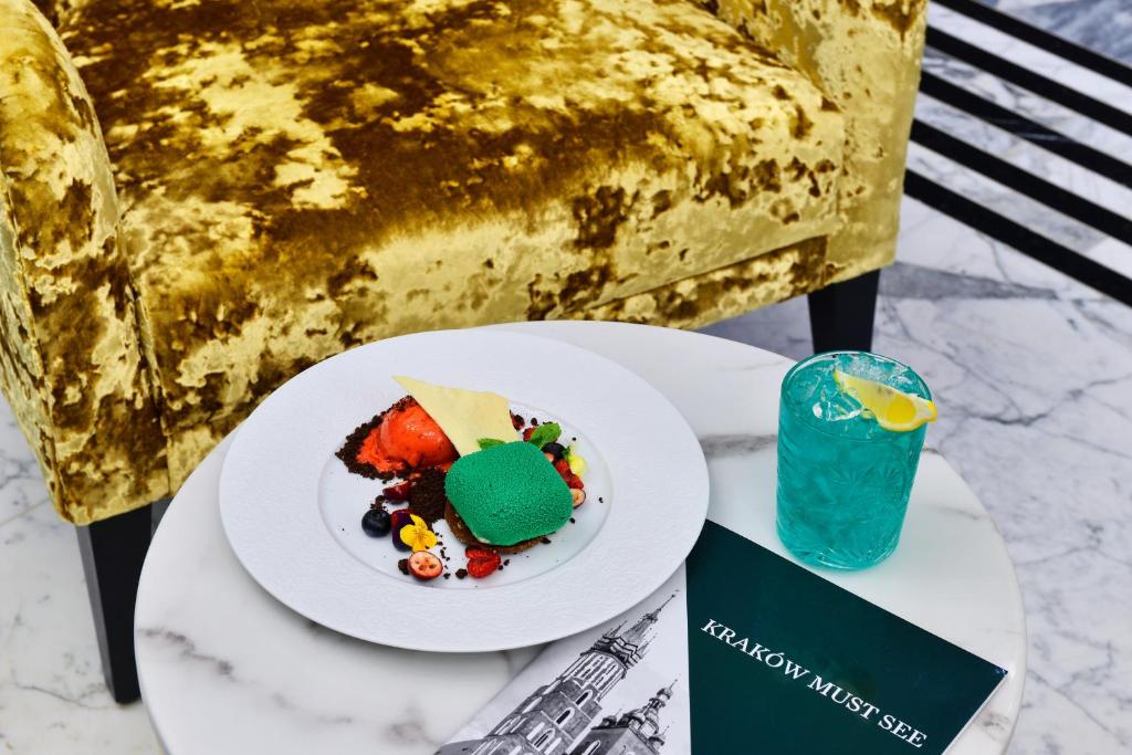 a plate of food on a table with a drink at Hotel Ferreus Modern Art Deco in Krakow