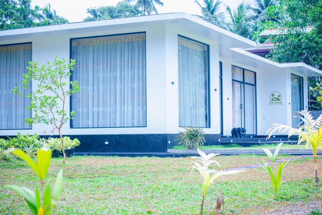 a small white house with large windows at The Glade in Weligama