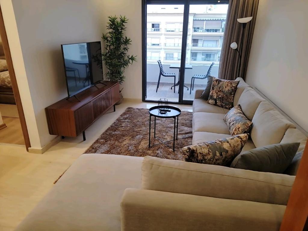 Appartement Parc Mohammedia في المحمدية: غرفة معيشة مع أريكة وتلفزيون