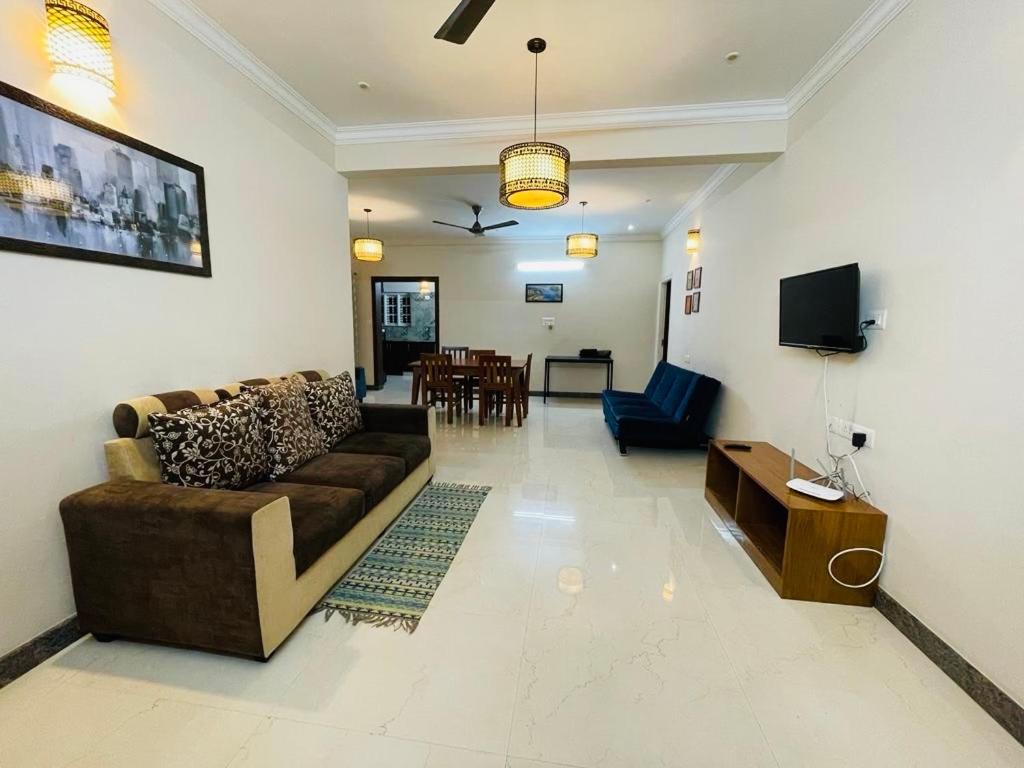 sala de estar con sofá y TV en The Canopy House en Bangalore