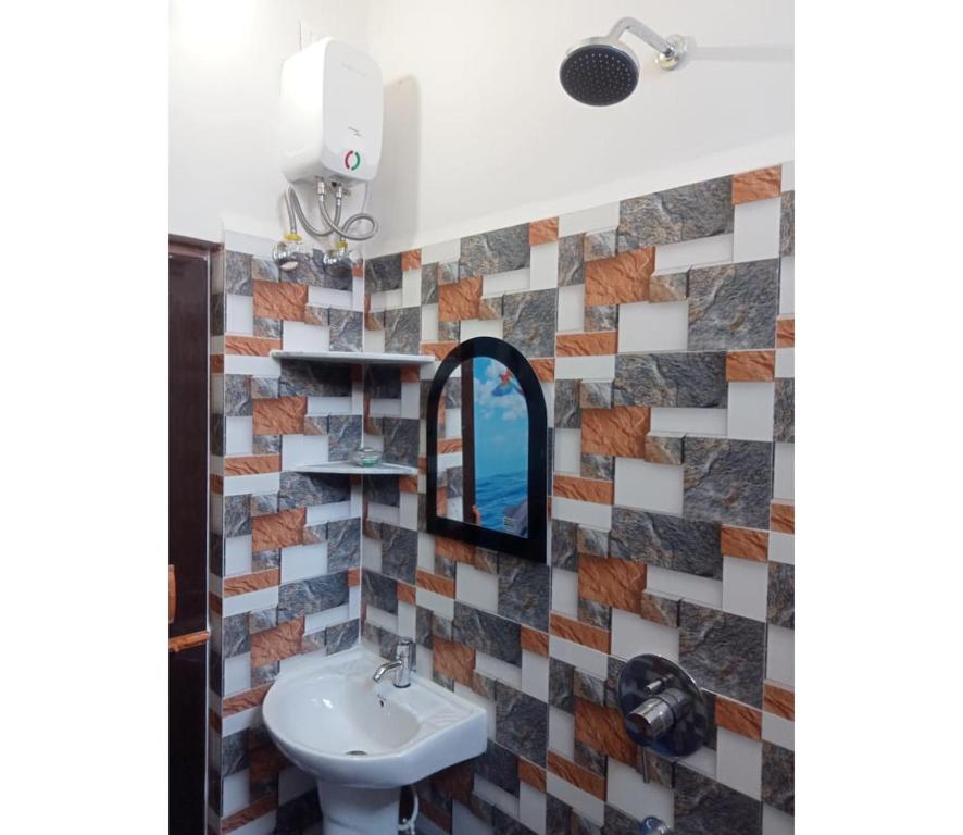 a bathroom with a sink and a mirror at Nidhivan Residency in Navadwīp