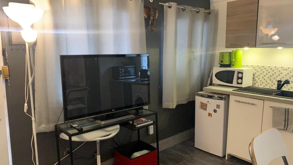 een kleine keuken met een groot scherm in een kamer bij Adorable studio 20m2 in Aubervilliers