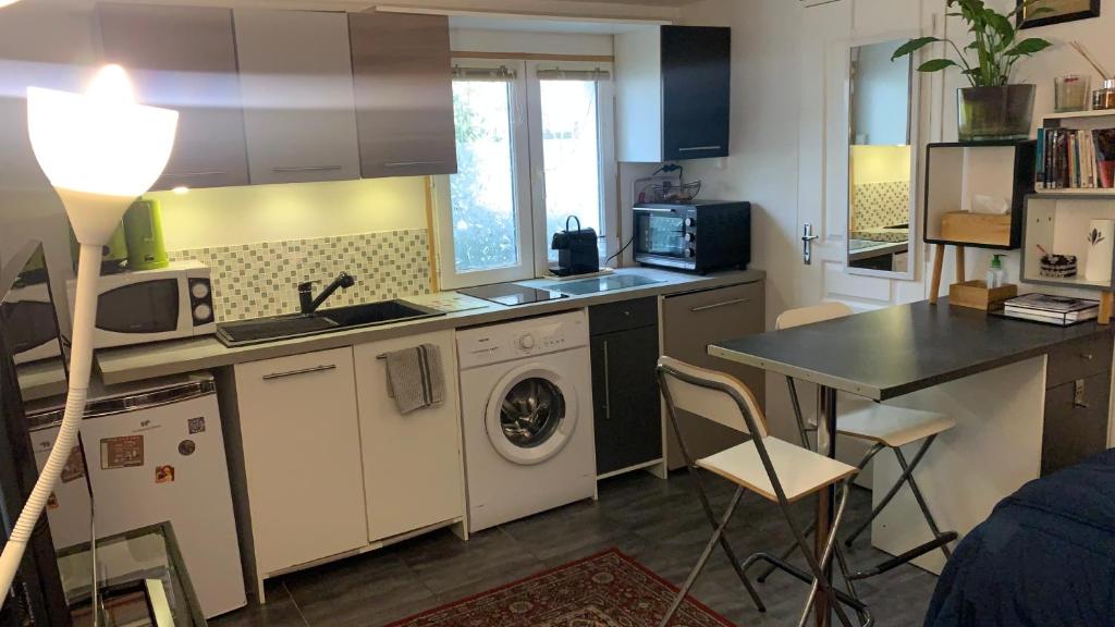 eine kleine Küche mit einer Waschmaschine und einem Tisch in der Unterkunft Adorable studio 20m2 in Aubervilliers