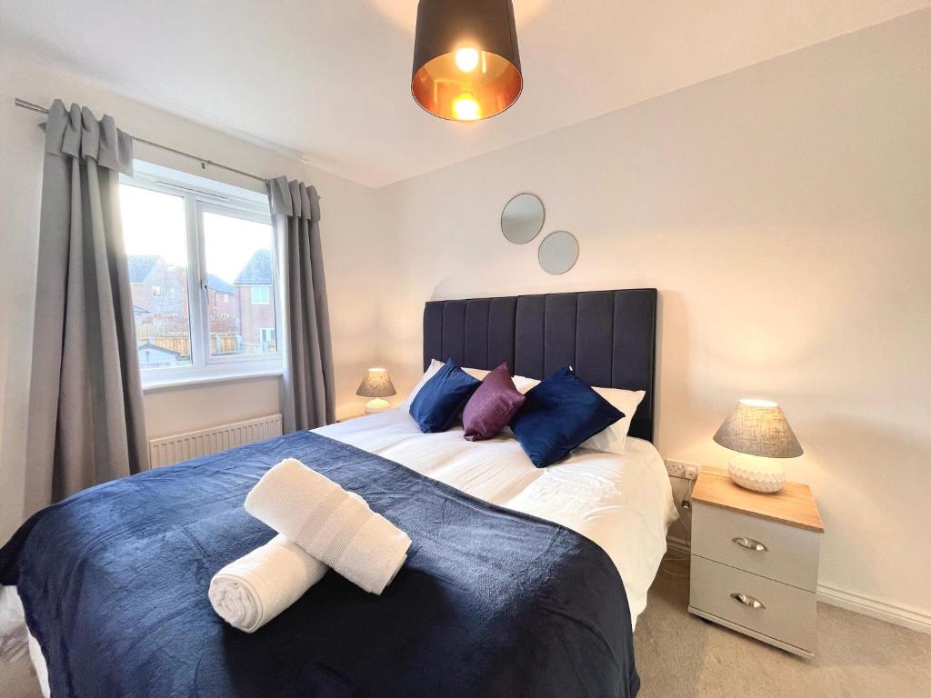 1 dormitorio con 1 cama grande con almohadas azules y moradas en Genesis 3 bedroom Home Telford- sleeps up to 5 en Oakengates