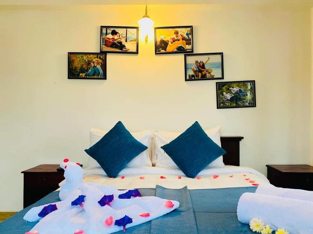 sypialnia z łóżkiem z obrazami na ścianie w obiekcie Thilina Hotel w mieście Nuwara Eliya