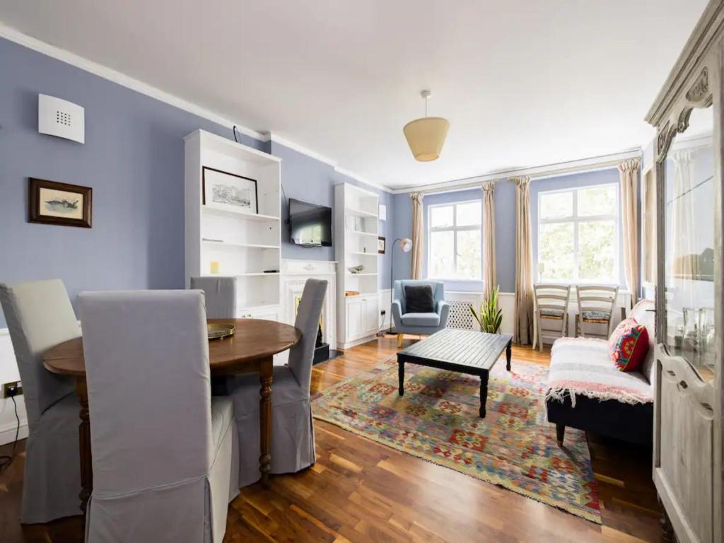 een woonkamer met een tafel en een eetkamer bij Pass the Keys Spacious and central 2 bedroom flat in Chelsea in Londen