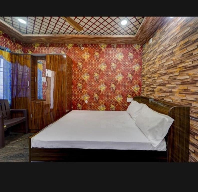 1 dormitorio con 1 cama en una pared de ladrillo en JK Residency, en Padappai