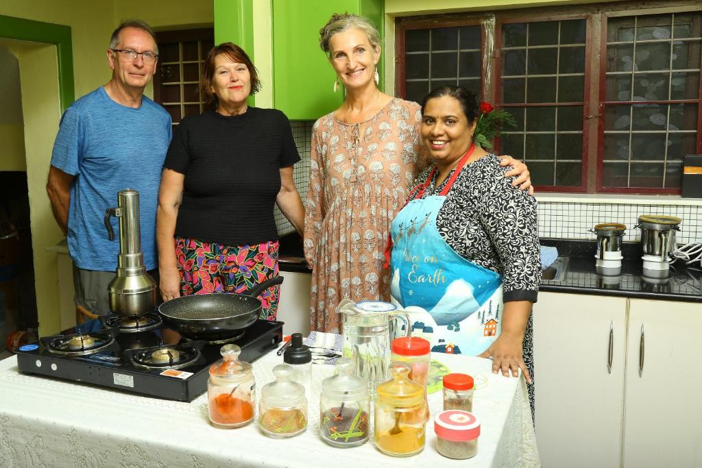 a group of people standing in a kitchen at Jasmin Villa in Cochin