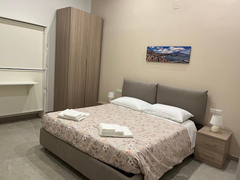 a bedroom with a bed with two towels on it at Neapolis francy Vesuvio in Naples
