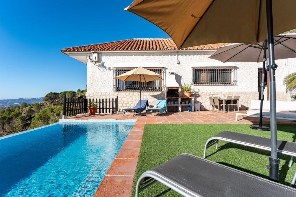 una casa con piscina e ombrellone di Villa Fenavista a Mijas