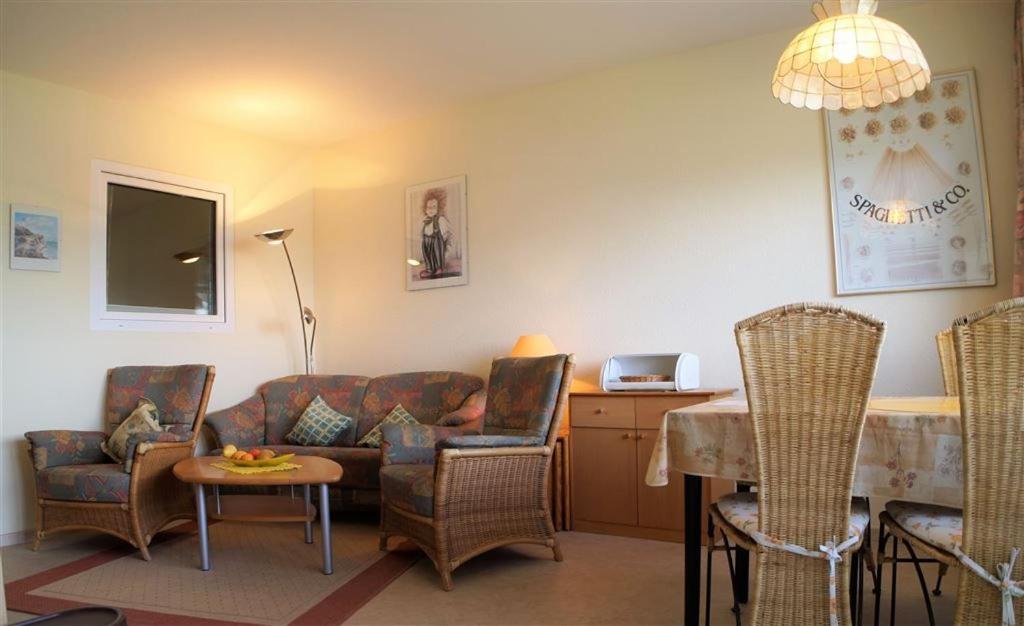 uma sala de estar com um sofá, cadeiras e uma mesa em Ferienpark - Haus G, App 0G0308 em Heiligenhafen