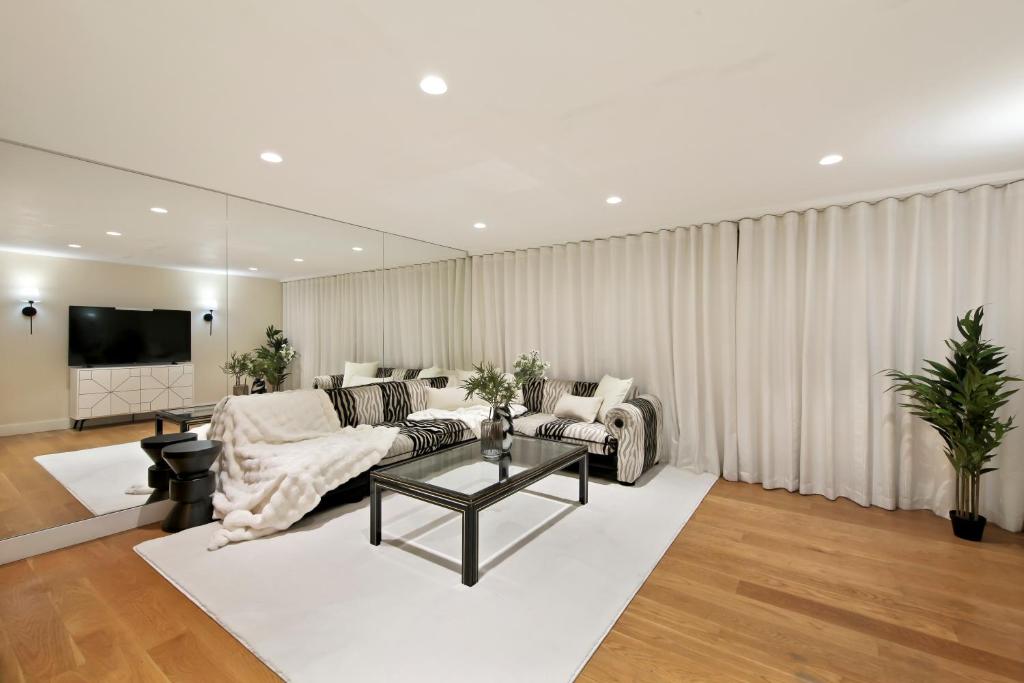 ein Wohnzimmer mit einem Sofa und einem Tisch in der Unterkunft Hububb Luxury Apartment Kensington in London