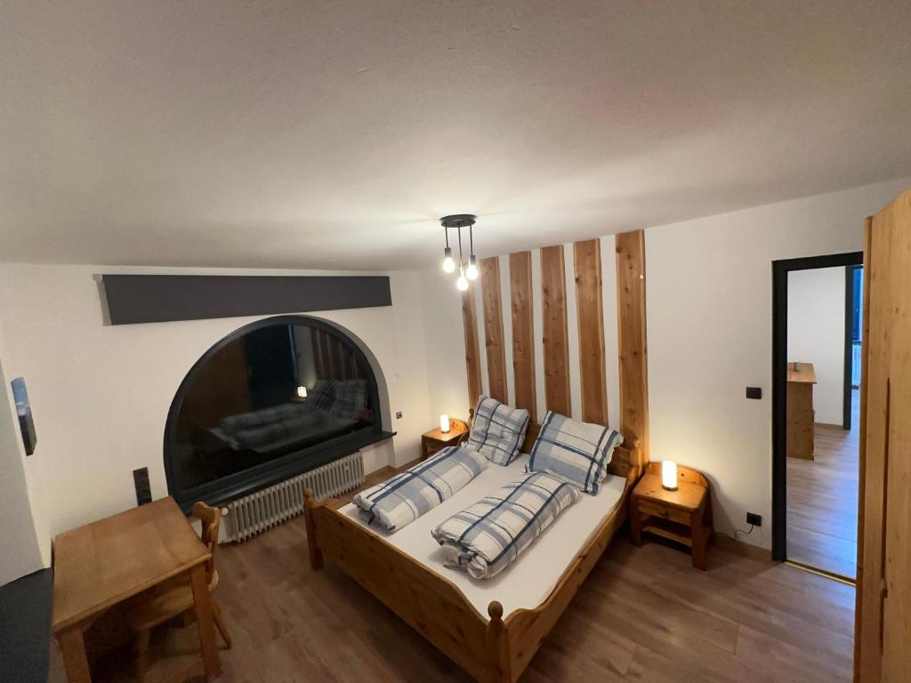Schlafzimmer mit einem Bett, einem Kamin und einem TV in der Unterkunft FeWo Bay Schwäbeleholz mit 2 Schlafzimmern in Sonthofen
