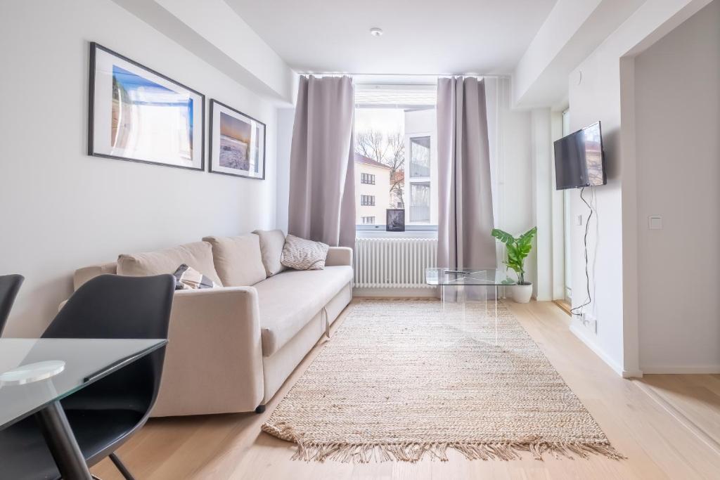 uma sala de estar com um sofá e uma mesa em A new apartment in Helsinki em Helsinque