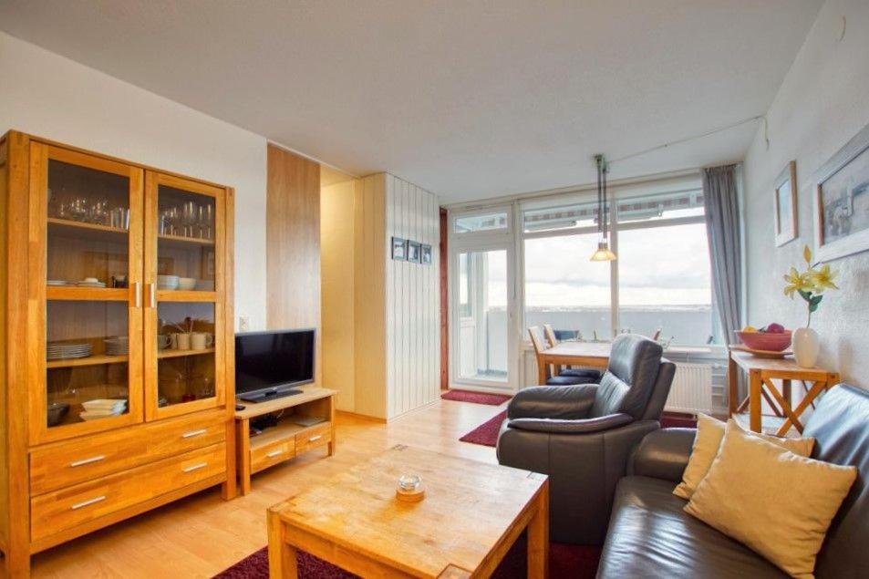 ein Wohnzimmer mit einem Sofa und einem TV in der Unterkunft Ferienpark - Haus G, App 0G1003 in Heiligenhafen
