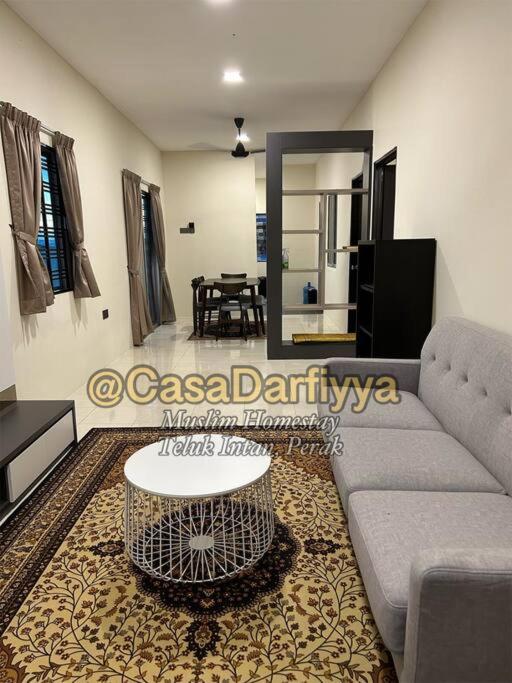 ein Wohnzimmer mit einem Sofa und einem Tisch in der Unterkunft Casa Darfiyya Homestay utk Muslim jer in Teluk Intan