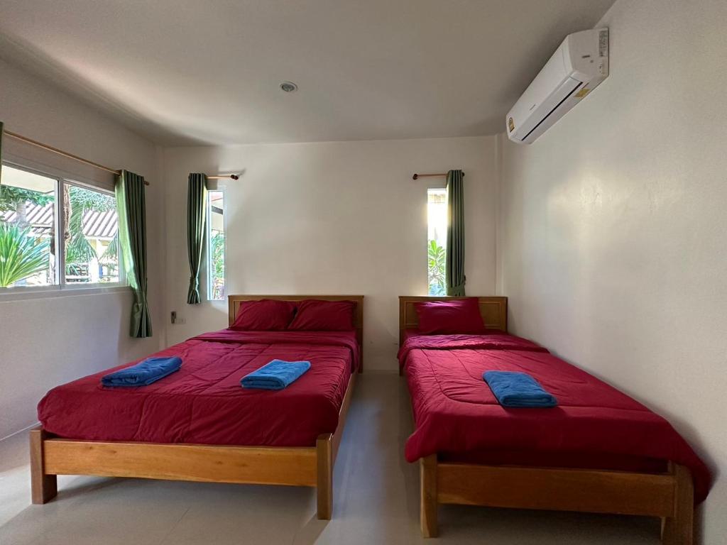 two beds in a room with red sheets at Sea Shell Beach Resort in Ko Lanta