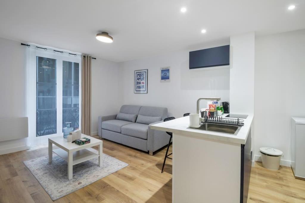 Hotel 11.Appart 4pers#1 Bedroom#Pigalle#Opéra#Paris 9, a kitchen and a living room with a couch at 11.Appart 4pers#1 Bedroom#Pigalle#Opéra#Paris 9 in Paris