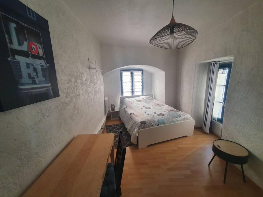 ein Schlafzimmer mit einem Bett und einem Tisch darin in der Unterkunft Hypercentre historique Daurade in Toulouse