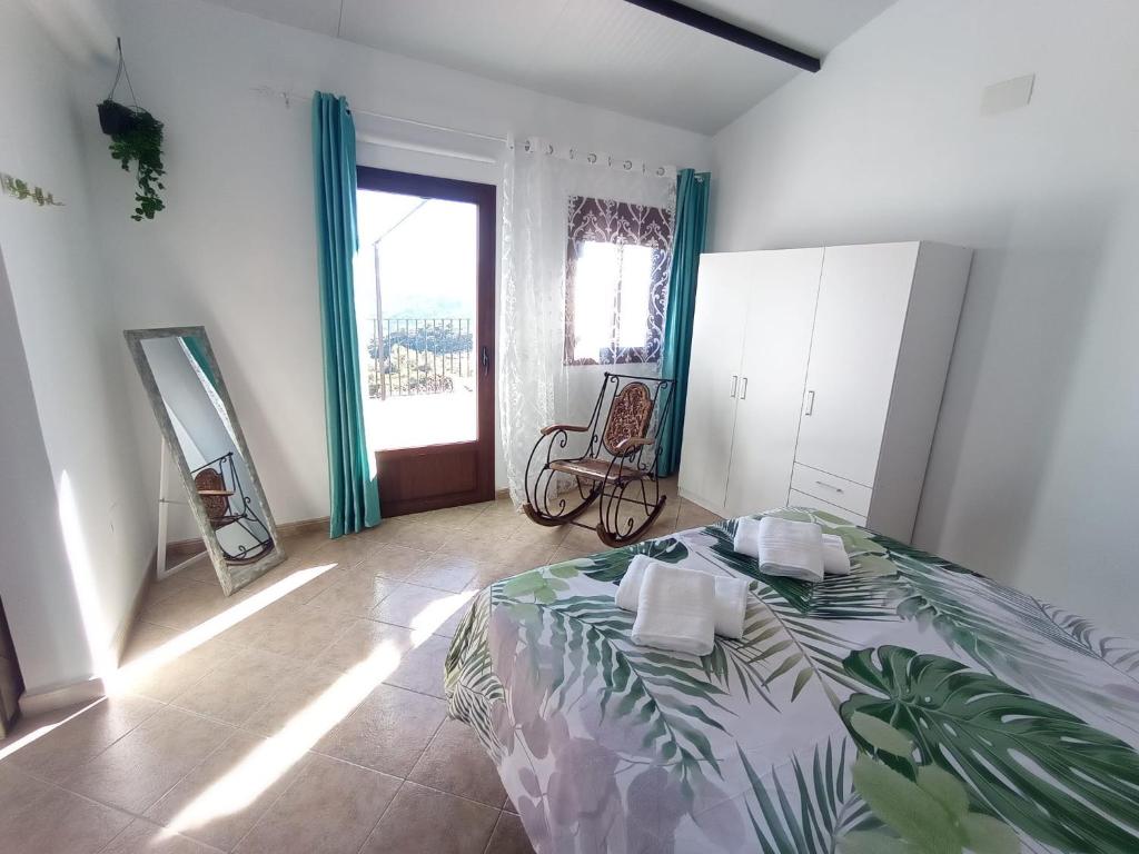 sypialnia z łóżkiem i dużym oknem w obiekcie Apartamento Valle del Guadiaro w mieście Cortes de la Frontera