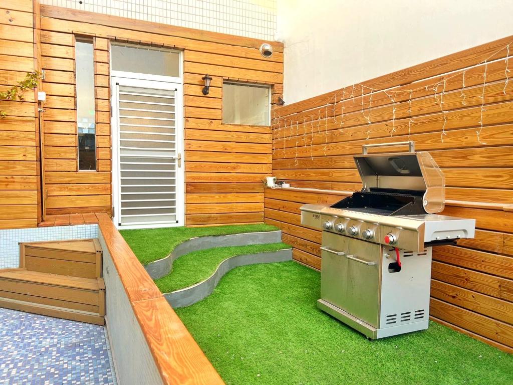 a backyard with a grill and green grass at Casa de Jumbo in Anping