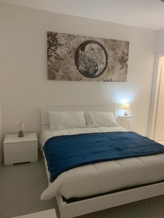 1 dormitorio con 1 cama y una pintura en la pared en La casa di Gio', en Fiumicino