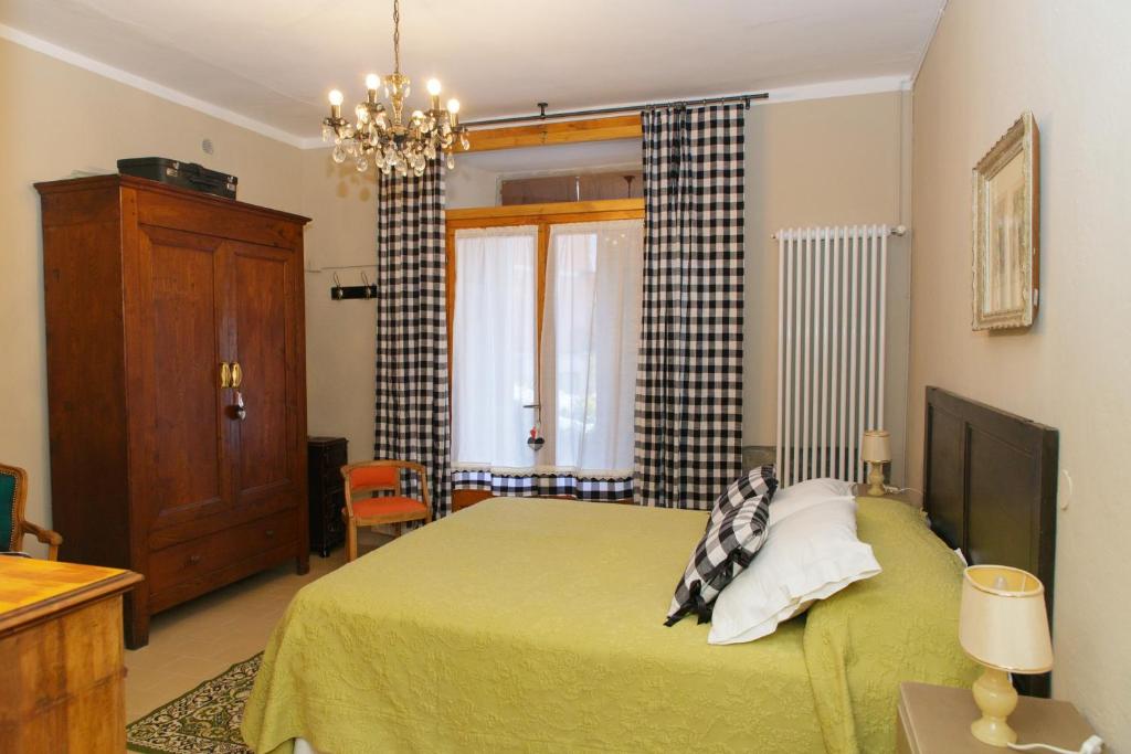 a bedroom with a green bed and a window at Casa Pini Rio_B in Riolunato