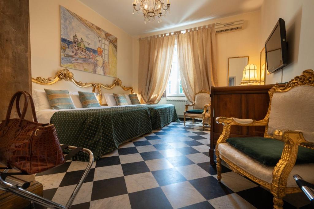 a bedroom with two beds and a chair and a tv at Morali Palace in Genoa