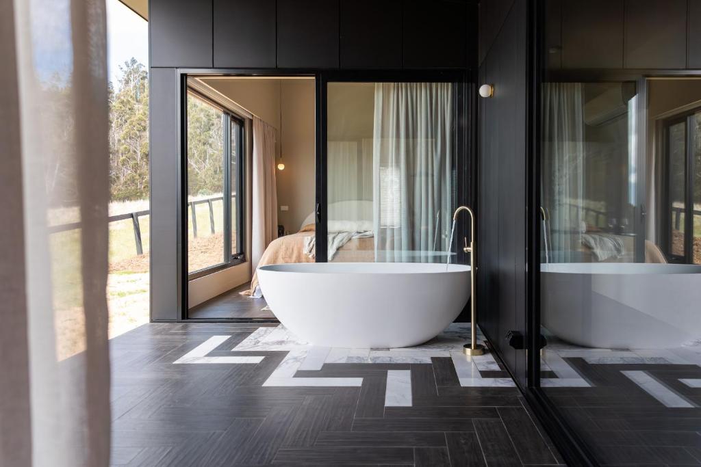 a bathroom with two bath tubs in a room at Wherewithal Luxury Suites in Carlton