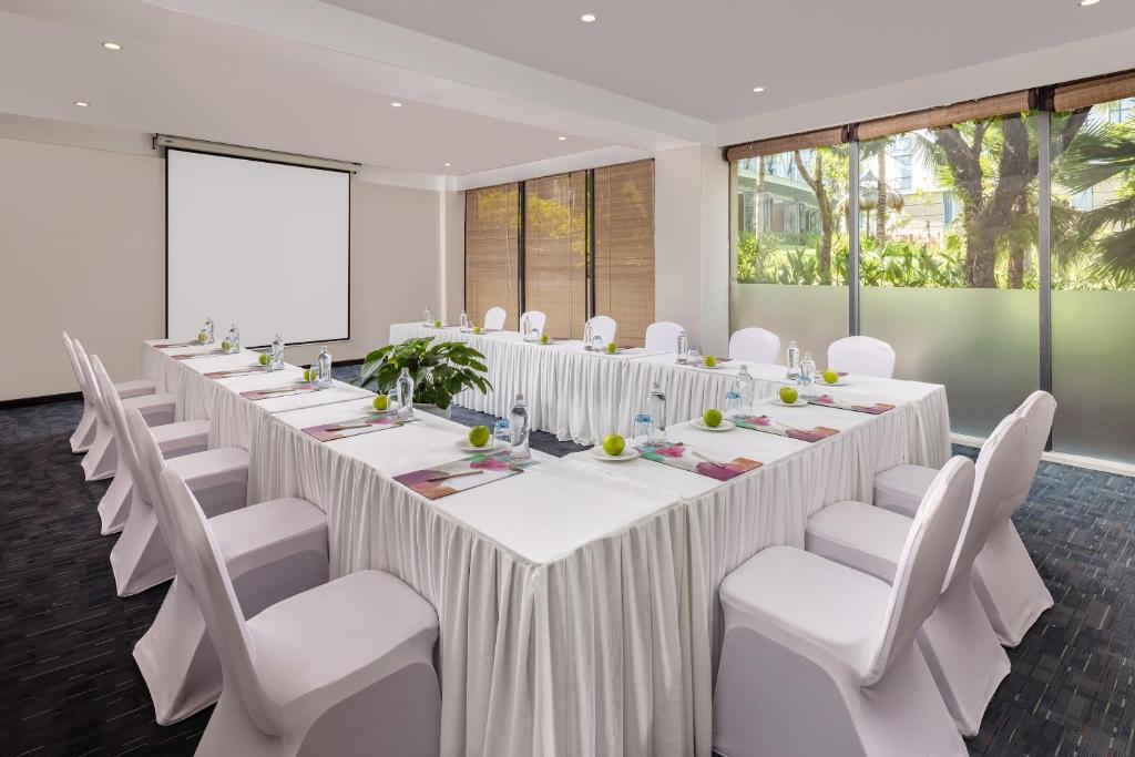 A naturally lit meeting room arranged around a square of tables.