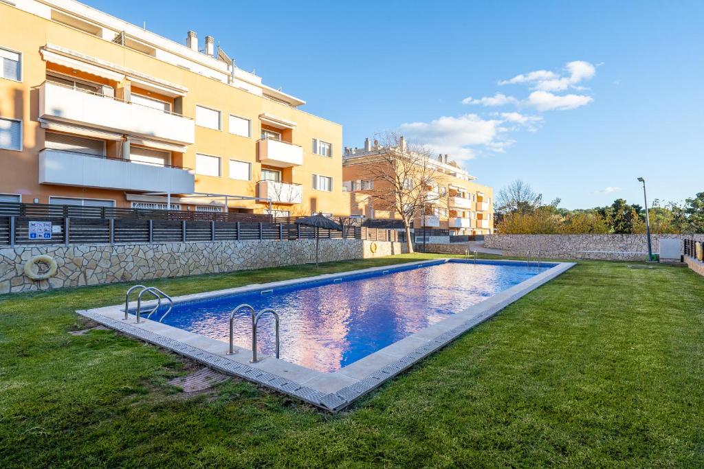 - une piscine dans une cour à côté d'un bâtiment dans l'établissement Hauzify I Apartament Balmanya 2A, à Sant Feliu de Guíxols