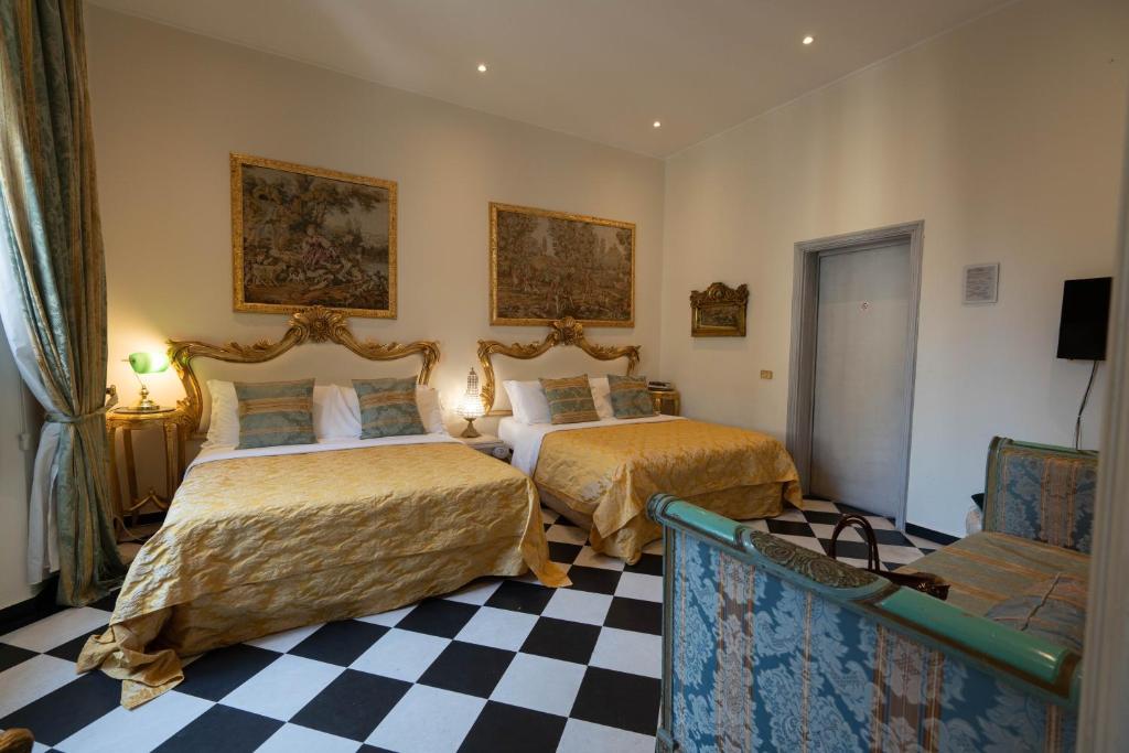 a bedroom with two beds and a checkered floor at San Giorgio Rooms in Genoa