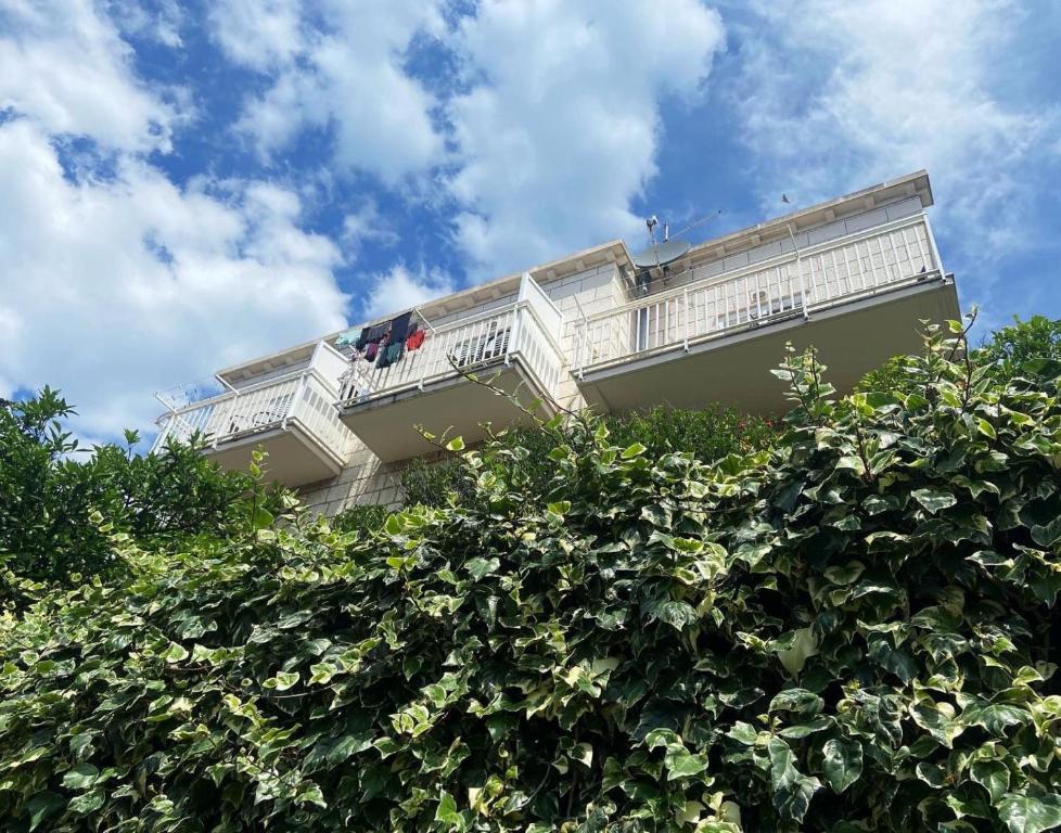 a building with a balcony on top of a bush at Villa Mar Vintage Apartments in Dubrovnik