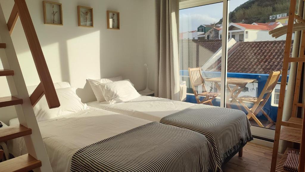Porto Pim Guest House في أورتا: غرفة نوم بسرير وشرفة مطلة