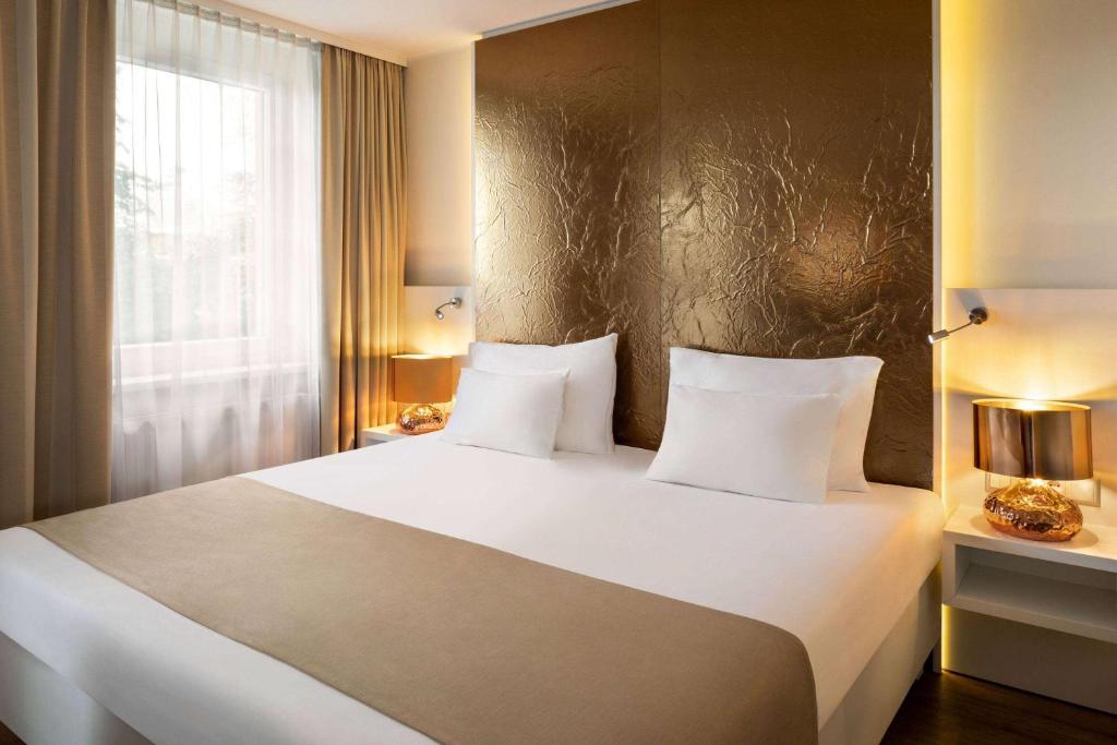 sypialnia z dużym białym łóżkiem i oknem w obiekcie Amedia Luxury Suites Graz, Trademark Collection by Wyndham w Grazu
