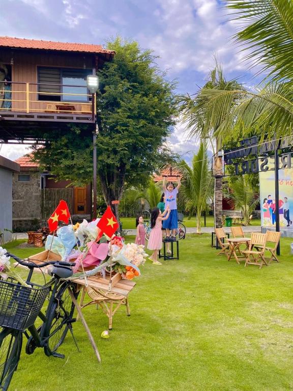 a group of people in a park with chairs and a statue at Bum King Resort Hồ Tràm in Xuyên Mộc