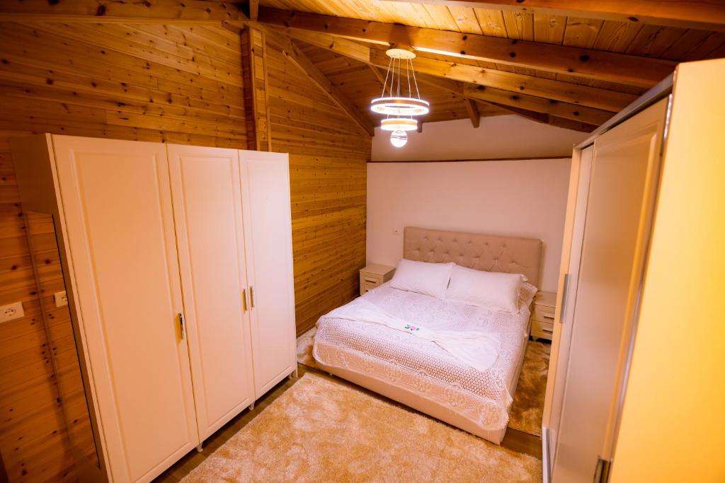 a small bedroom with a bed and two closets at House La Frateli in Korçë