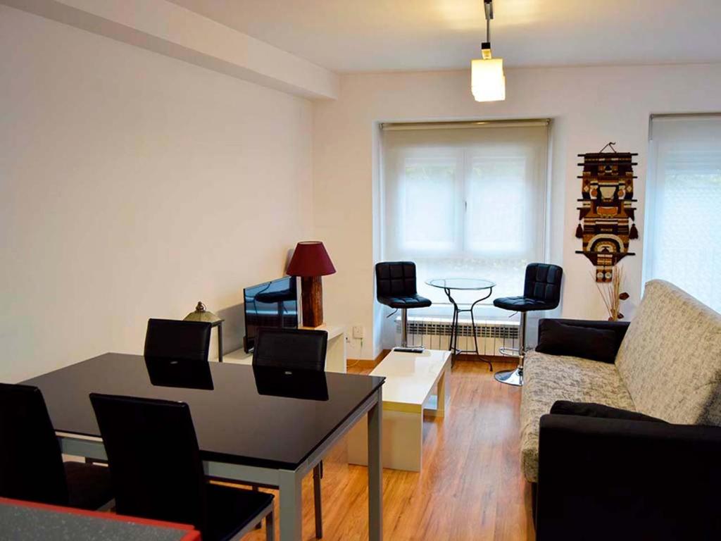 a living room with a table and chairs at Apartamentos Jaca Ciudadela 3000 in Jaca