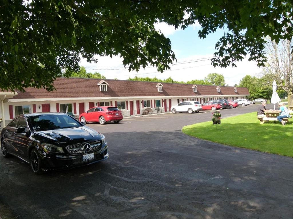 a black car parked in front of a building at Country Squire Motel in Arnprior