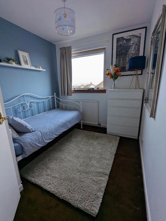 a blue bedroom with a bed and a window at Single room with Castle view in leafy Edinburgh South in Edinburgh