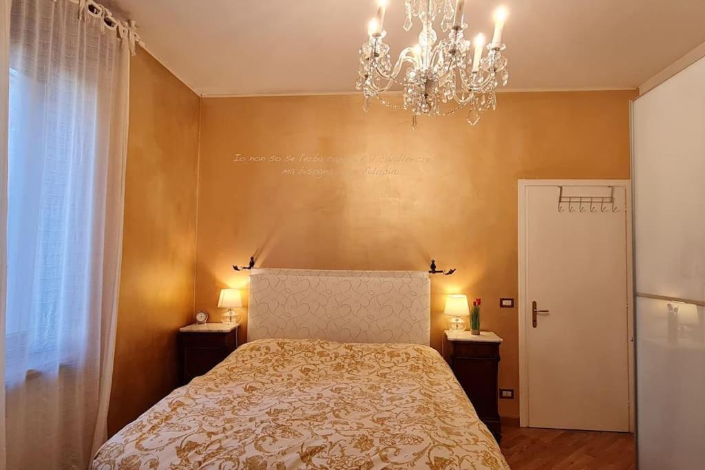 Luxury Verona Apartment City Centre في فيرونا: غرفة نوم بسرير وثريا