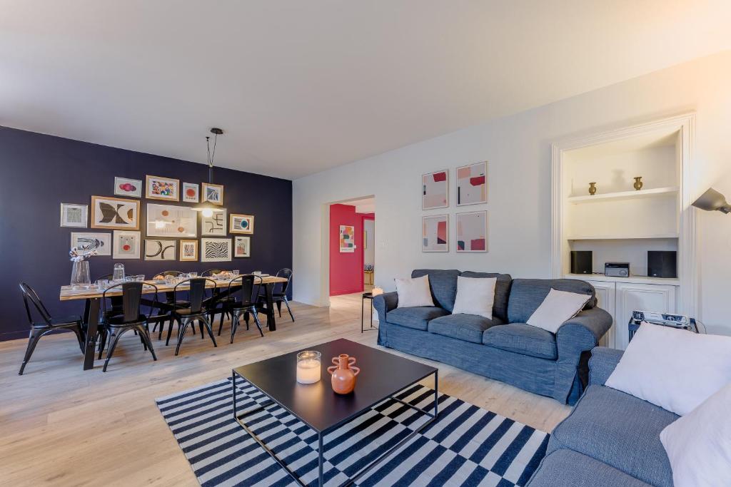 uma sala de estar com um sofá azul e uma mesa em Haxo - Superbe appt en centre ville pour 7 em Nantes