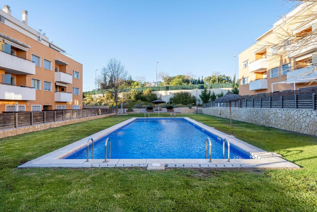 una piscina en un patio junto a un edificio en Hauzify I Apartament Balmanya 2D, en Sant Feliu de Guíxols