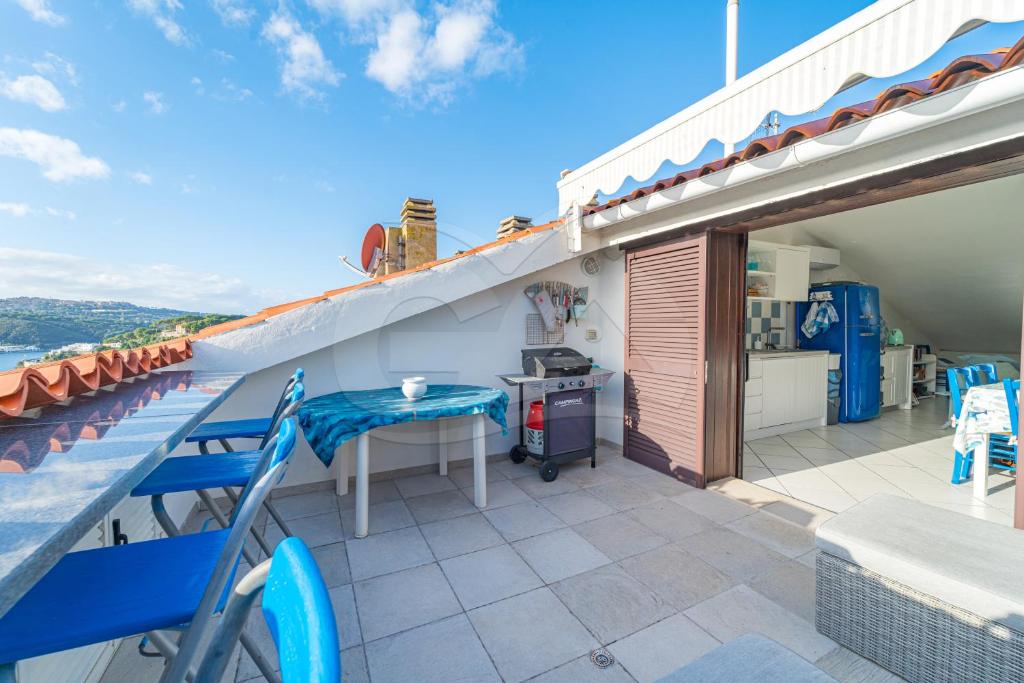 a patio with a table and chairs on a balcony at Il Porto 25 Mansarda sul Mare - Goelba in Porto Azzurro