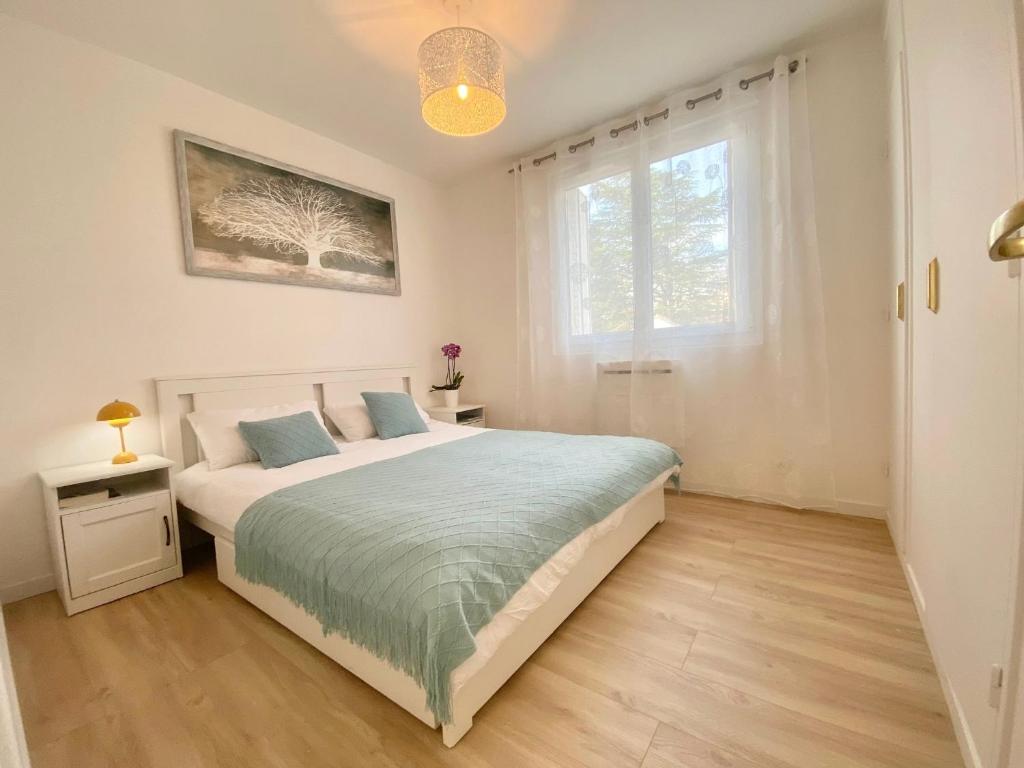 a bedroom with a large bed and a window at Appart Laffitte joli T2 au coeur du parc & parking & RER pour Paris & La Défense in Maisons-Laffitte