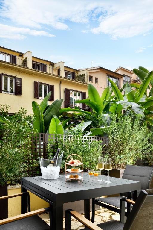 stół z jedzeniem i kieliszkami do wina na balkonie w obiekcie Margutta 19 - Small Luxury Hotels of the World w Rzymie