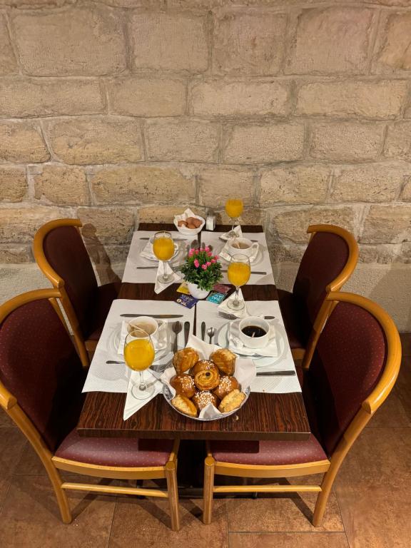 a table with a plate of food and glasses of orange juice at 121 Paris Hotel in Paris
