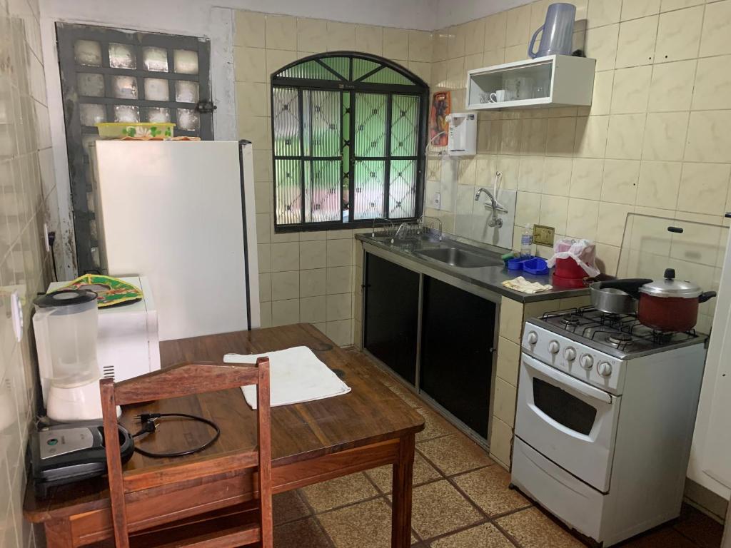 uma cozinha com um fogão, um frigorífico e uma mesa em Samambaia 01 em Brasília