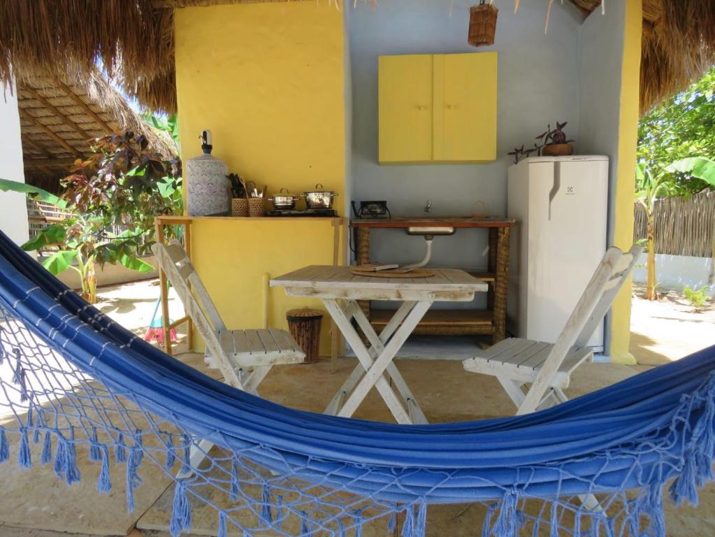 a kitchen with a table and a refrigerator at Pitico - Pousada Icaraí Kite Village in Icaraí