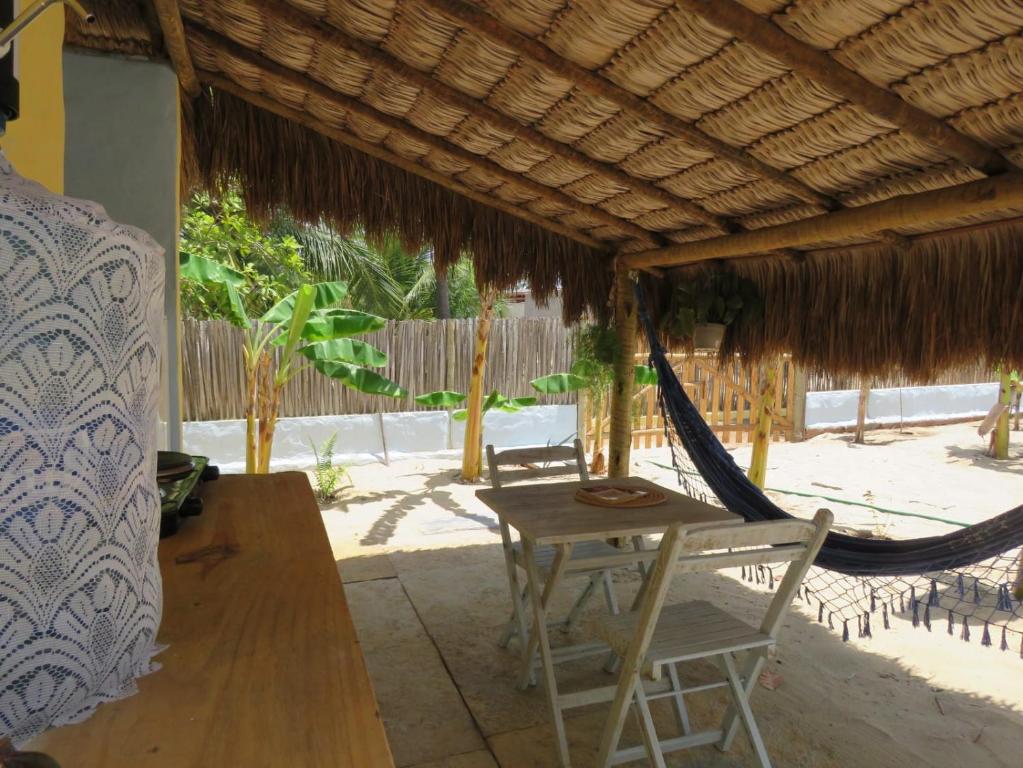 a porch with a hammock and a table and chairs at Pitico - Pousada Icaraí Kite Village in Icaraí